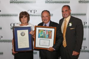 Michael J. Landi, President, Transit Managerial Benevolent Association (center) shows off plaque presented to him by last year's honoree, Anthony Franco. Maryann McAleer. QCP's Director of Development, shows off Proclamation the Mr. Landi also received.